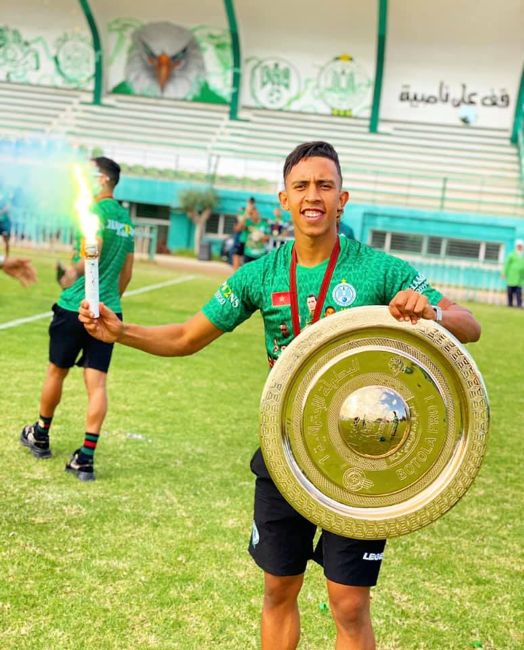 Sofiane Rahimi celebrating while holding the Botola Pro 1 trophy