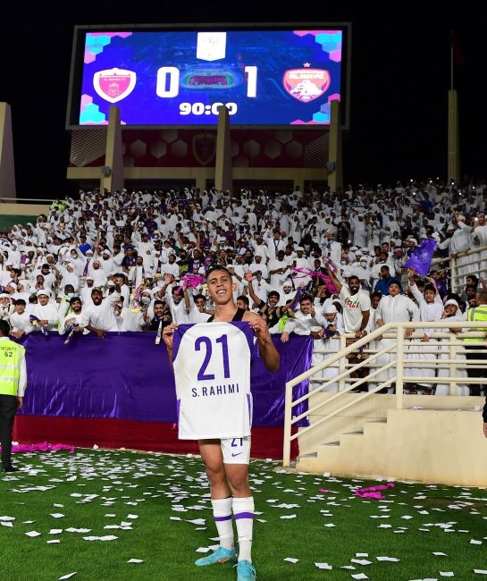 Soufiane Rahimi holding his Al Ain FC's jersey number 21