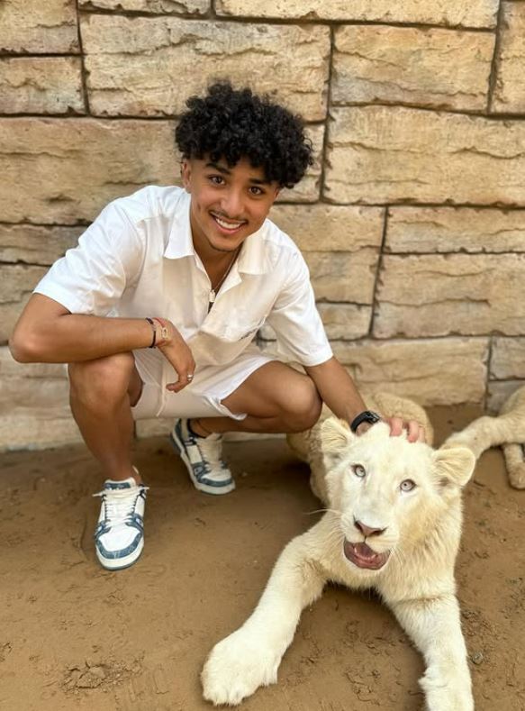 El Mehdi El Khamlich posing with a cub during his visit to aa wildlife park in Dubai, UAE